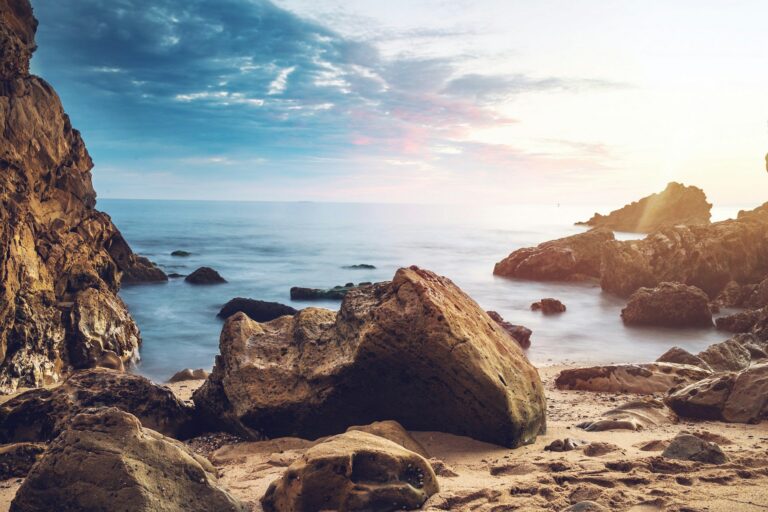 Coté sauvage, on y voit des rechers, du sable et la mer.