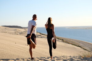 Deux personne faisant du sport sur la plage lors d'un séjour en thalassothérapie.