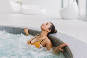 Une femme se prélasse dans un jacuzzi.